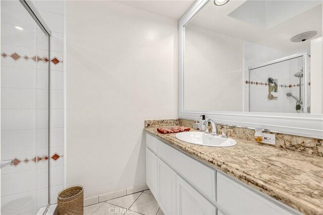 bathroom featuring a stall shower, tile patterned flooring, and vanity