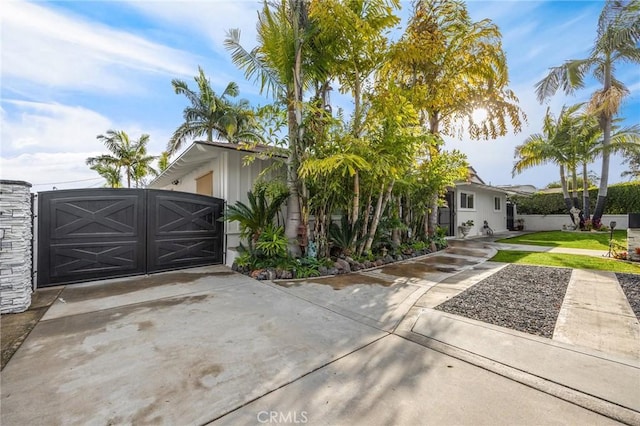 view of front of home with driveway and a gate