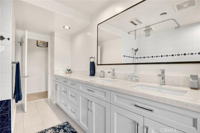 bathroom featuring double vanity, tile patterned flooring, walk in shower, recessed lighting, and baseboards