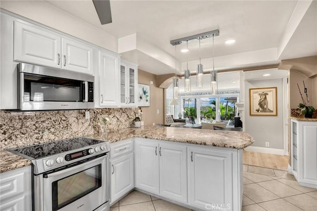 kitchen with stainless steel appliances, white cabinetry, light tile patterned floors, and glass insert cabinets