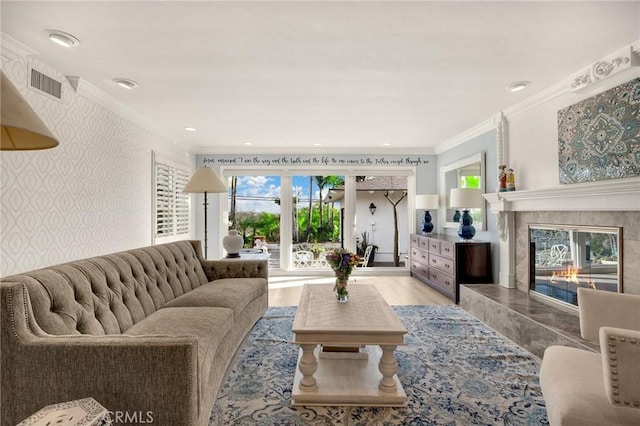 living area featuring wallpapered walls, crown molding, a high end fireplace, and wood finished floors