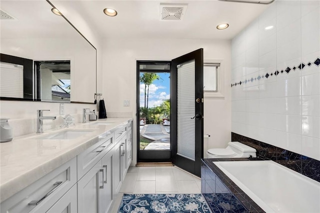 bathroom featuring double vanity, a garden tub, tile patterned flooring, recessed lighting, and toilet