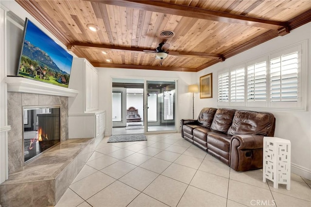 living area featuring wooden ceiling, light tile patterned floors, ceiling fan, beamed ceiling, and a premium fireplace