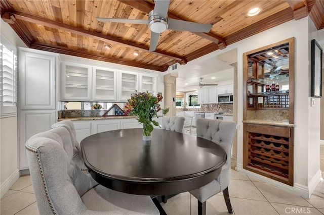 dining room with wooden ceiling, a ceiling fan, light tile patterned floors, decorative columns, and baseboards