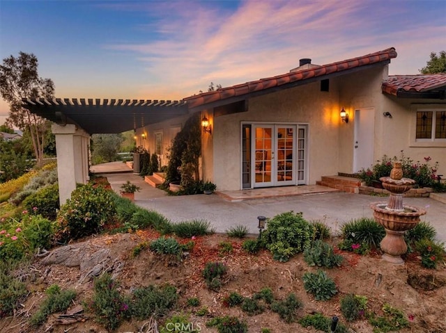 37895 Avenida Bravura, Temecula, CA 92592 - back of house at dusk featuring french doors, a patio, stucco siding, and a tiled roof