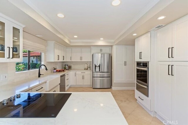 37895 Avenida Bravura, Temecula, CA 92592 - kitchen featuring appliances with stainless steel finishes, a warming drawer, decorative backsplash, glass insert cabinets, and light stone countertops