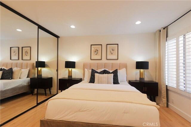 bedroom featuring light wood-style floors, recessed lighting, baseboards, and a closet