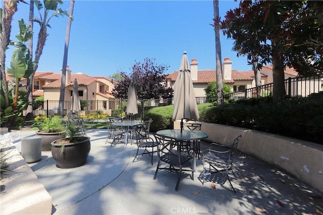 view of patio with outdoor dining space, a residential view, and fence