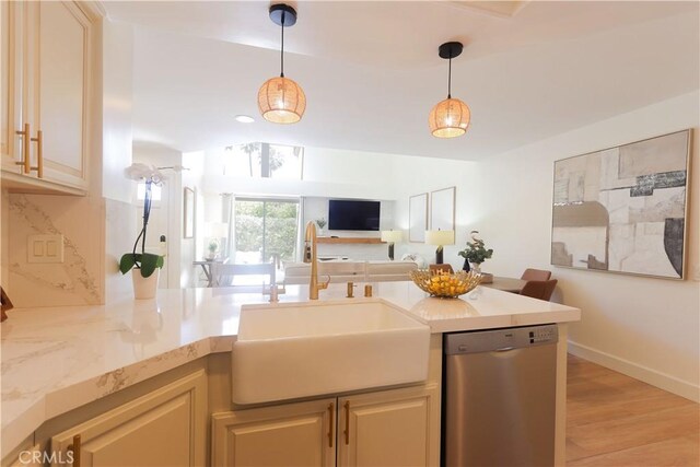 kitchen with dishwasher, a sink, open floor plan, and hanging light fixtures