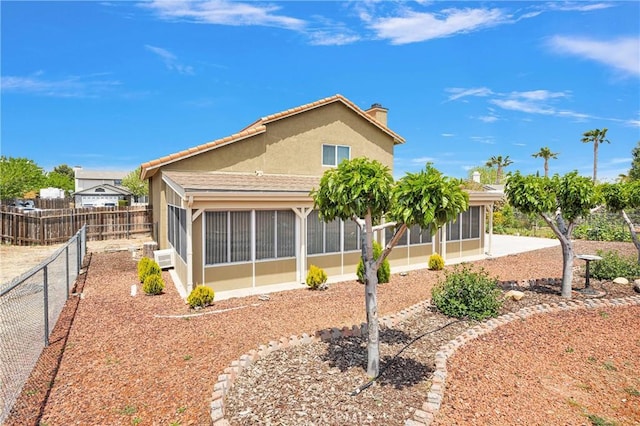15199 Farmington Ct, Hesperia, CA 92345 - rear view of property featuring a sunroom, stucco siding, a chimney, and a fenced backyard