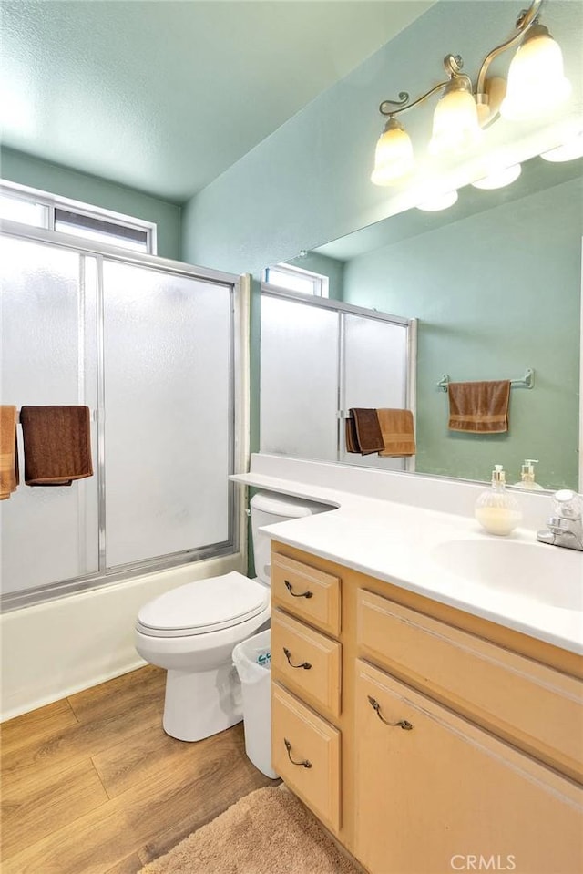 15199 Farmington Ct, Hesperia, CA 92345 - full bathroom featuring toilet, wood finished floors, vanity, and shower / bath combination with glass door