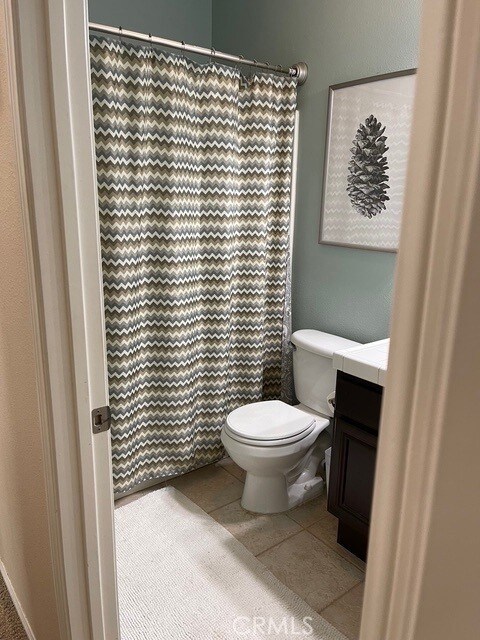 124 Lighthouse Ct, San Jacinto, CA 92583 - full bath featuring toilet, vanity, a shower with curtain, and tile patterned flooring