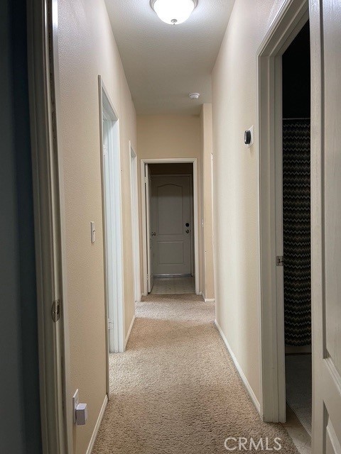 124 Lighthouse Ct, San Jacinto, CA 92583 - hall with light carpet and baseboards