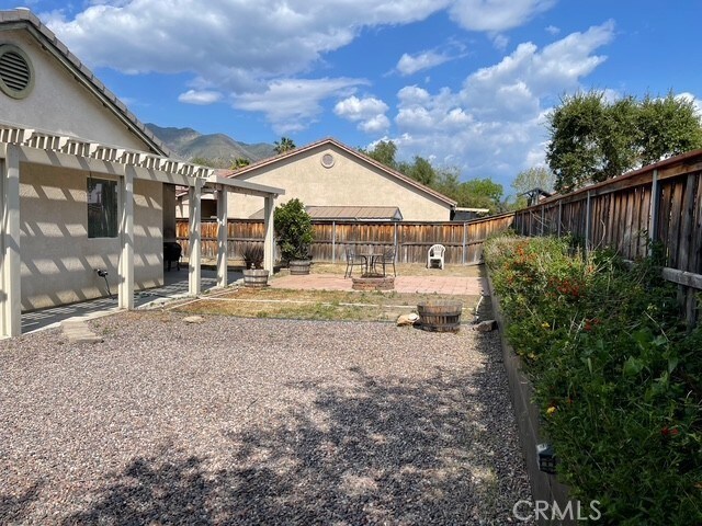 124 Lighthouse Ct, San Jacinto, CA 92583 - fenced backyard featuring a pergola, a patio, and a mountain view