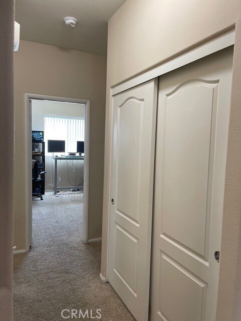 124 Lighthouse Ct, San Jacinto, CA 92583 - corridor featuring light colored carpet and a desk