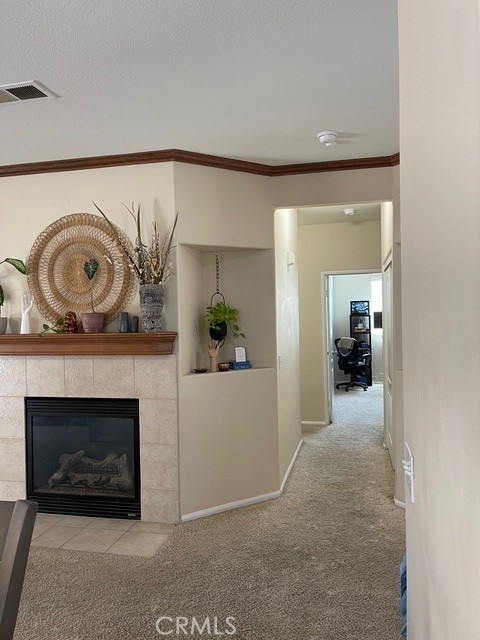 124 Lighthouse Ct, San Jacinto, CA 92583 - hallway featuring carpet flooring, ornamental molding, baseboards, and a textured ceiling