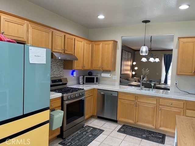 124 Lighthouse Ct, San Jacinto, CA 92583 - kitchen featuring appliances with stainless steel finishes, under cabinet range hood, light tile patterned floors, pendant lighting, and recessed lighting