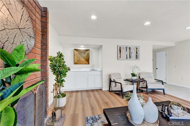 living area featuring baseboards, recessed lighting, and light wood finished floors