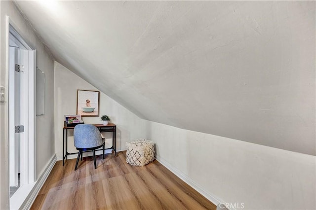 office space with vaulted ceiling, wood finished floors, and baseboards