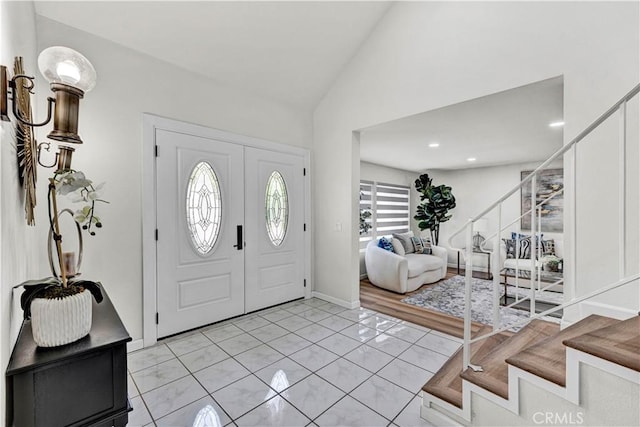 foyer featuring stairs, vaulted ceiling, light tile patterned floors, and recessed lighting