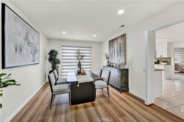 dining room featuring light wood-type flooring, baseboards, and recessed lighting