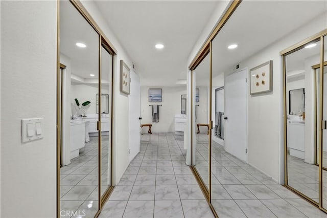 corridor with recessed lighting and light marble finish floors