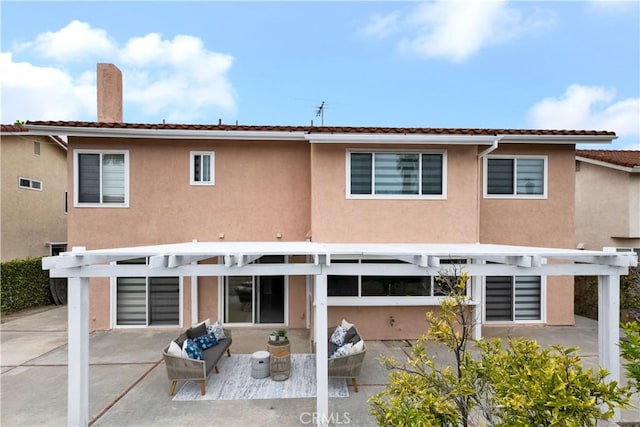 back of property featuring a pergola, a patio area, an outdoor hangout area, and stucco siding