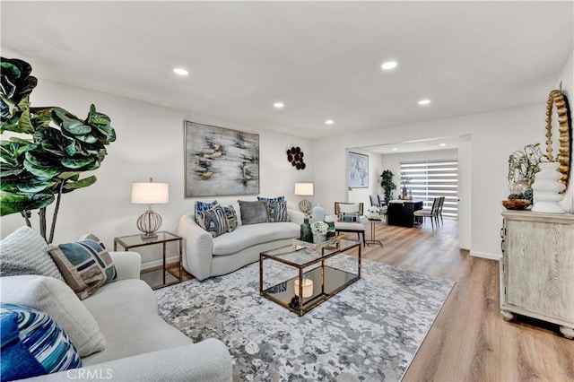 living room with light wood-type flooring and recessed lighting