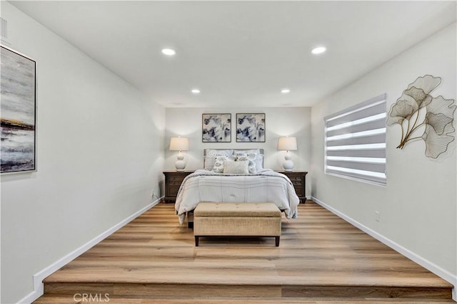 bedroom with recessed lighting, wood finished floors, and baseboards