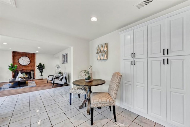 dining space featuring recessed lighting and a brick fireplace