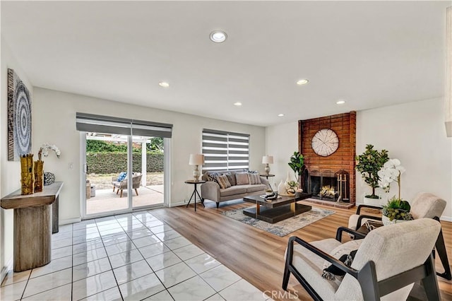 living area with a brick fireplace, recessed lighting, and baseboards