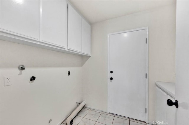 washroom with cabinet space, hookup for a gas dryer, electric dryer hookup, and light tile patterned floors