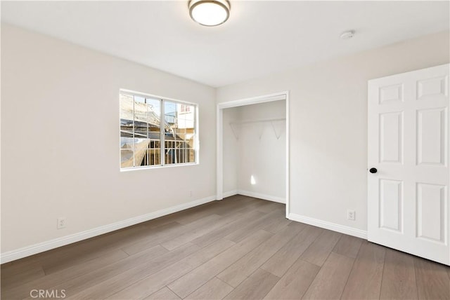 823 E 3rd St, Pomona, CA 91766 - unfurnished bedroom featuring wood finished floors, baseboards, and a closet