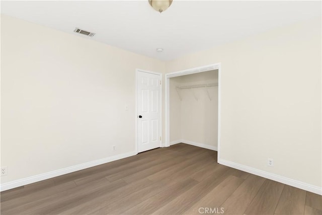 823 E 3rd St, Pomona, CA 91766 - unfurnished bedroom with wood finished floors, baseboards, and a closet