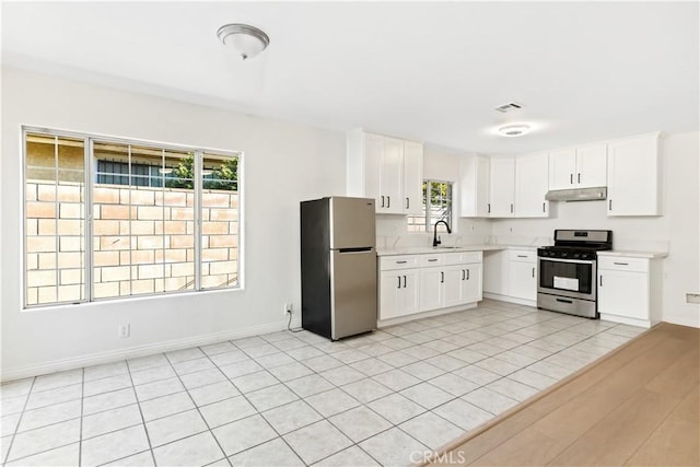 823 E 3rd St, Pomona, CA 91766 - kitchen featuring appliances with stainless steel finishes, under cabinet range hood, light countertops, and plenty of natural light