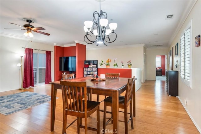 dining room featuring light wood-style flooring, ceiling fan, crown molding, a chandelier, and baseboards