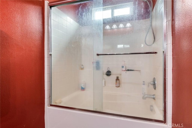 full bath featuring a textured wall and enclosed tub / shower combo