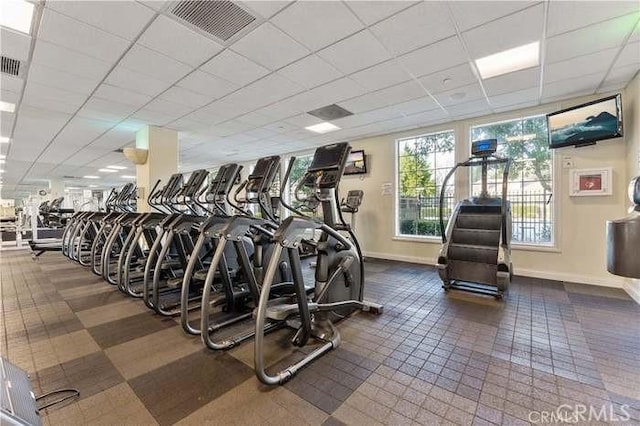 gym with baseboards and a drop ceiling