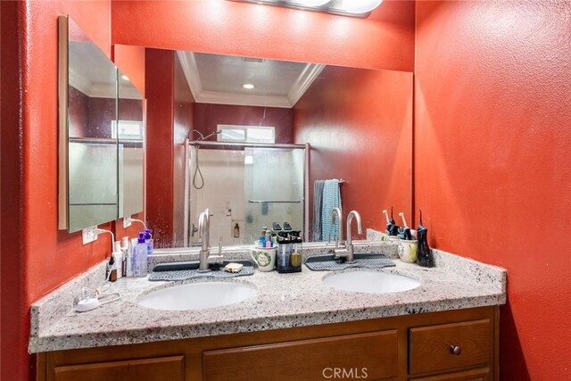 full bathroom with a stall shower, ornamental molding, double vanity, and a textured wall