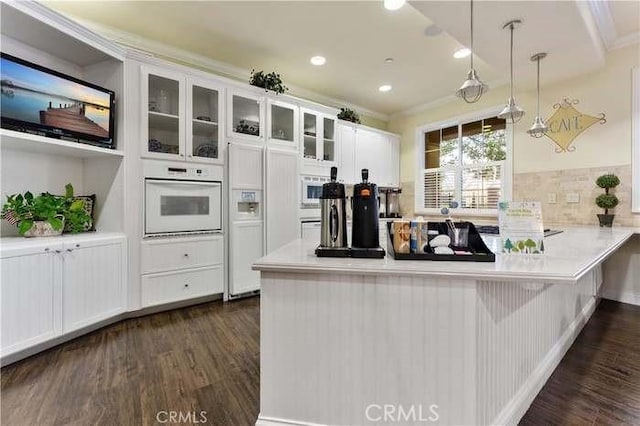 kitchen featuring white appliances, dark wood-style flooring, white cabinetry, a peninsula, and recessed lighting