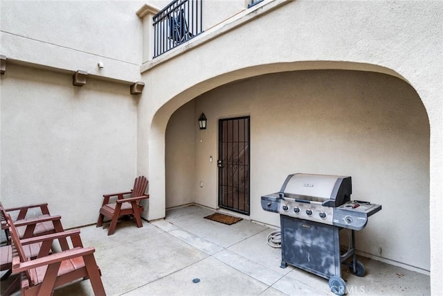 view of patio featuring area for grilling and a balcony