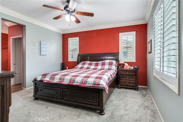 carpeted bedroom with crown molding, baseboards, and ceiling fan