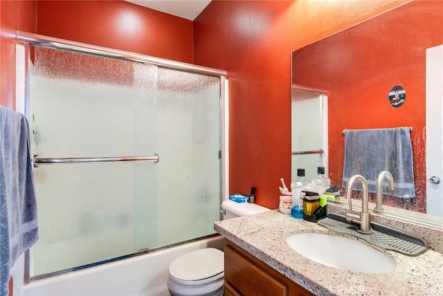 full bathroom with toilet, combined bath / shower with glass door, and vanity