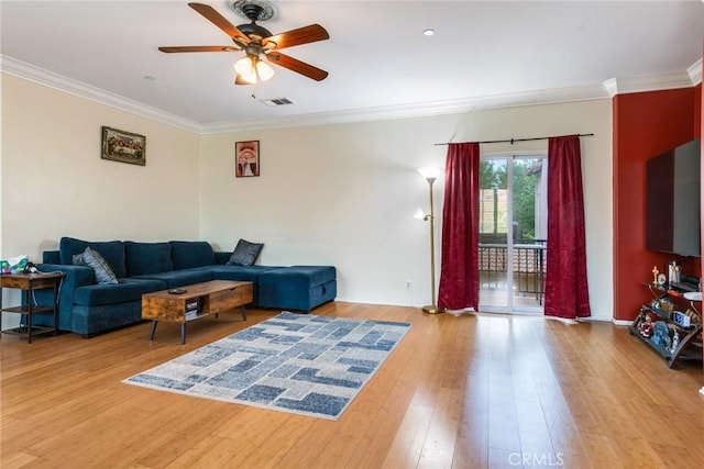 living room featuring ceiling fan, ornamental molding, light wood-type flooring, and baseboards