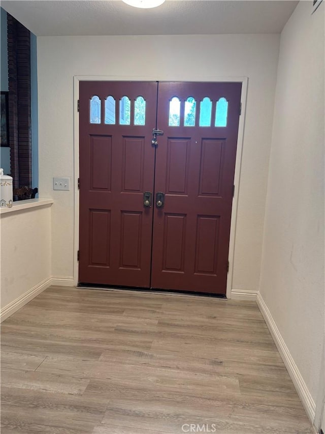 entryway with baseboards and light wood-type flooring