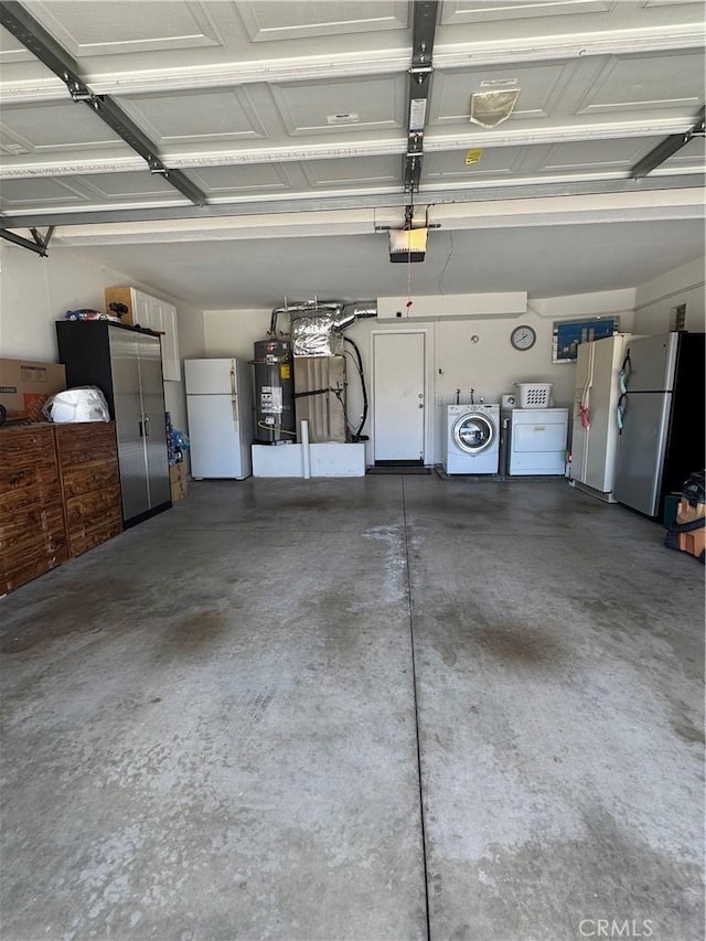 garage featuring freestanding refrigerator, secured water heater, independent washer and dryer, and white refrigerator with ice dispenser