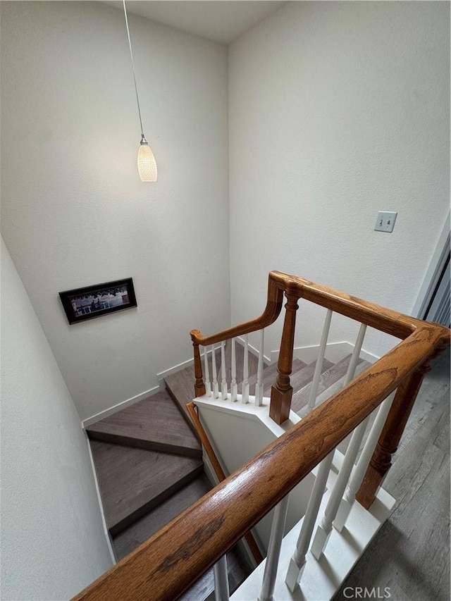 stairs featuring wood finished floors and baseboards