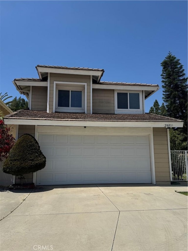 traditional-style home featuring an attached garage and concrete driveway