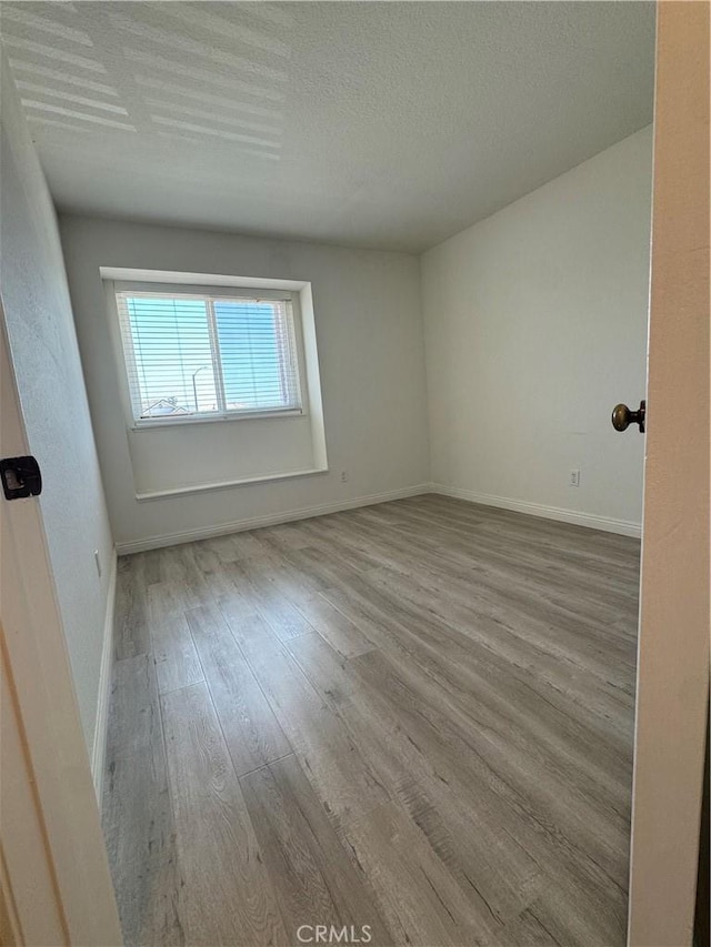 2801 Woodview Ct, Walnut, CA 91789 - empty room with wood finished floors and a textured ceiling