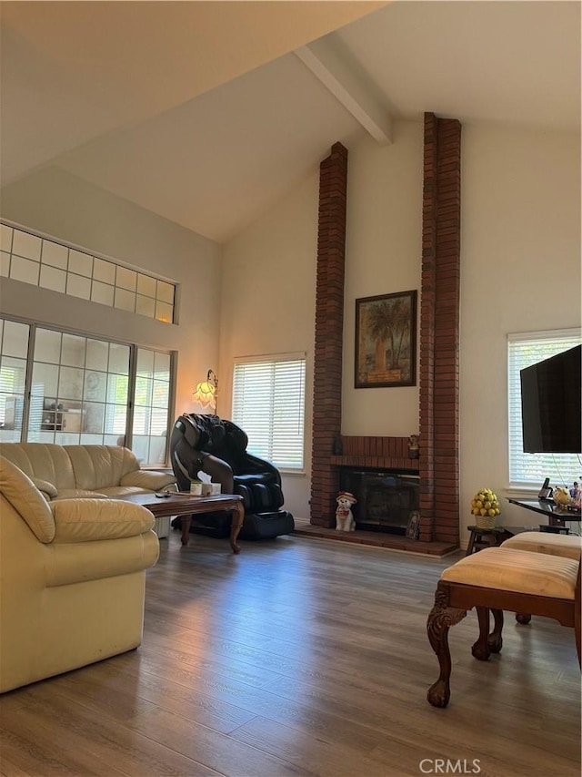 living room featuring high vaulted ceiling, beamed ceiling, wood finished floors, plenty of natural light, and a fireplace